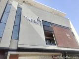 The image shows the exterior of a modern building with a flat roof. The building appears to be a commercial or industrial str...