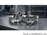 The image shows a group of six stainless steel pipes and fittings arranged on a metal surface. The pipes are arranged in a ne...