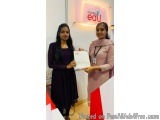 The image shows two young women standing in front of a sign that reads "Crystal EDU Care". The woman on the left is wearing a...