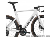 The image is of a white Canyon Ultimate CF SLX Disc bicycle. The bike has a sleek and modern design with a black saddle and h...