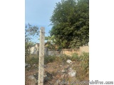 The image shows a tall, white pole with a chain-link fence surrounding it. The fence appears to be old and weathered, with pe...