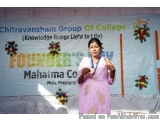The image shows a young woman standing in front of a banner that reads "Chitravansham Group of College (Knowledge Brings Ligh...