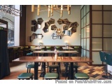 The image shows the interior of a modern restaurant or cafe. The walls are painted in a light grey color and the floor is mad...