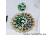 The image shows a decorative item, which appears to be a peacock feather brooch. The brooch is made up of a circular base wit...