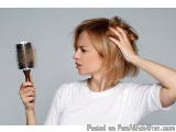 The image shows a young woman with blonde hair, holding a hairbrush in her right hand and combing her hair. She is wearing a...