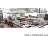 The image shows a modern commercial kitchen with a large stainless steel countertop and a long island in the center. The coun...