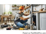 In this image, we can see a man wearing an orange hard hat and overalls, kneeling on the floor in a kitchen. He is working on...