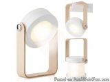 The image shows a modern wall-mounted light fixture with a unique design. The fixture is made of a white material with a gold...