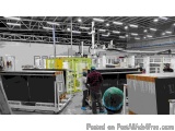 The image shows a large industrial space with a high ceiling and multiple levels. The space appears to be a factory or worksh...