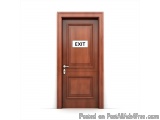 The image shows a wooden door with an exit sign on it. The door is rectangular in shape and has a dark brown finish. The word...