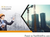 The image is a collage of two elements. On the left side, there is a man wearing a suit and an orange hard hat, holding a blu...