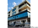 The image is a photograph of a modern building with a blue sky in the background. The building appears to be a two-story stru...