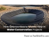 The image shows a large circular pond with a black geomembrane sheet covering it. The pond is surrounded by small rocks and p...