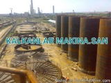 The image shows an industrial area with several large cylindrical structures, which appear to be oil storage tanks or storage...
