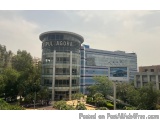The image shows a modern building with a circular shape and a glass facade. The building is located in a residential area wit...
