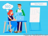 The image shows a man and a woman sitting at a desk with a laptop in front of them. The man is standing behind the desk and t...