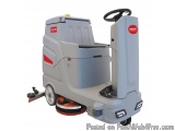 The image shows a floor scrubber dryer, which is a type of floor cleaning machine. It is a grey-colored machine with a red an...