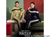The image shows two young women sitting on a green couch in a room with a red and green color scheme. They are both wearing t...