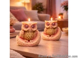 The image shows two small ceramic owls sitting on top of a wooden table. The owls are intricately carved with detailed featur...