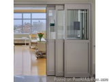 The image shows a modern office space with a large window that offers a view of the city. The room has a white floor and wall...