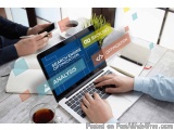 The image shows a laptop on a wooden table with a person's hands typing on the keyboard. On the laptop screen, there is a blu...