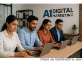 The image shows a group of four young people sitting around a wooden table with laptops in front of them. They are all lookin...