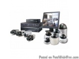 The image shows a collection of security cameras and a computer monitor. On the left side of the image, there is a black DVD...
