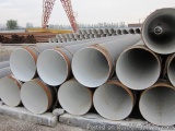 The image shows a stack of large, cylindrical pipes stacked on top of each other. The pipes appear to be made of steel or con...