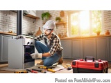 In this image, we can see a man wearing a white hard hat, a plaid shirt, and blue jeans, kneeling on the floor in front of a...