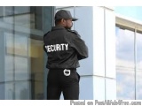 The image shows a man wearing a black jacket with the word "SECURITY" written on it in white letters. He is standing in front...