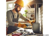 In this image, we can see a man wearing a yellow hard hat and overalls, working on a stove in a kitchen. He is holding a tool...