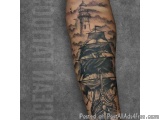 The image is a tattoo on someone's arm. It is a black and grey tattoo of a ship sailing on the water with a lighthouse in the...