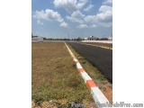 The image shows a long, straight road with a white and orange striped barrier on one side. The road appears to be empty, with...