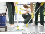 The image shows three people in a cleaning room, all wearing green uniforms and yellow rubber gloves. They are using mops to...