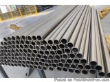 The image shows a stack of steel pipes in a warehouse. The pipes are arranged in a horizontal line and are stacked on top of...