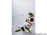 The image shows a flat lay of various medical supplies on a white marble background. On the left side of the image, there is...