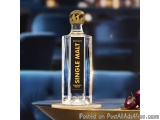 The image shows a bottle of Estuary Single Malt Scotch Whisky on a table in a restaurant. The bottle is tall and slender with...