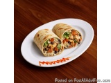 The image shows a plate with two wraps on it. The wraps are made of tortilla and are filled with a mixture of rice, meat, and...