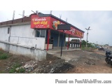 The image shows a small building with a red and yellow signboard on the side. The signboard has the words "Kerala" written in...