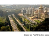 The image is an aerial view of a city with a large, ornate building in the center. The building appears to be a temple or a p...