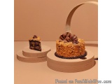 The image shows two cakes on a wooden cake stand. The cake on the left is a square cake with a slice taken out of it, reveali...