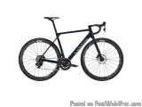 The image is of a blue-colored road bike. The bike has a sleek design with a black frame and handlebars. It has a disc brake...