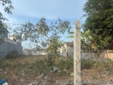 The image shows a barren landscape with a fence in the foreground. The fence is made of barbed wire and is located in the mid...