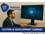 The image shows a man sitting at a desk in front of a computer monitor with a blue background. On the monitor screen, there i...
