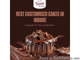 The image is an advertisement for a cake named "Best Customised Cakes in Indore". The background is dark brown and the cake i...