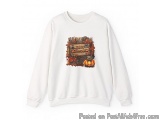 The image is of a white sweatshirt with a graphic design on the front. The design features a wooden sign with the words "Happ...