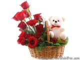 The image is of a basket filled with red roses. The basket is made of woven straw and is filled with greenery. On the right s...