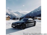 The image shows a black Mercedes-Benz S-Class car parked on a snowy road in front of a mountain range. The car is a luxury mo...
