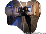 The image shows two young women standing in a server room, looking at their laptops. They are both wearing black outfits and...