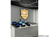 The image shows a modern and sleek design of a car dealership. The wall behind the counter is painted in a light grey color a...